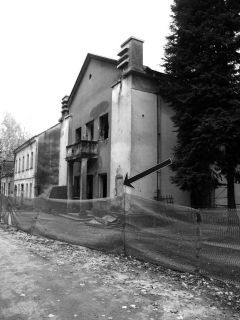 Balkon na zgradi Sportskog društva Sokol ("Sokolana") sa kojeg su 4/5. avgusta 1941. godine nesretnici, rasporenih trbuha bacani na drljače. (Strelica pokazuje mjesto na kome je do 1991. godine stajala spomen-ploča)