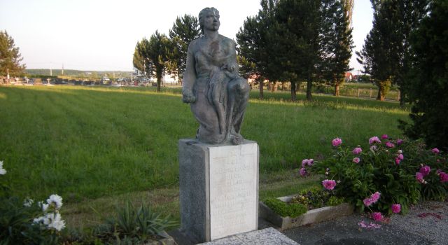 Споменик са погледом на пругу и гробље